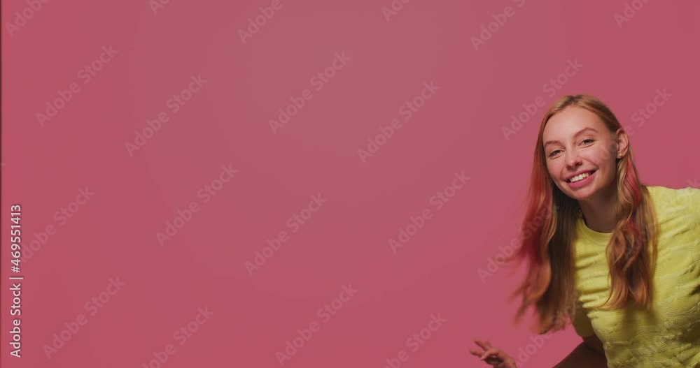 Happy young girl waving hand gesturing hello or bye, welcoming, greeting, smiling friendly peek in shot with copy space Happy young girl waving hand gesturing hello or bye, welcoming, greeting, smiling friendly peek in shot with copy space