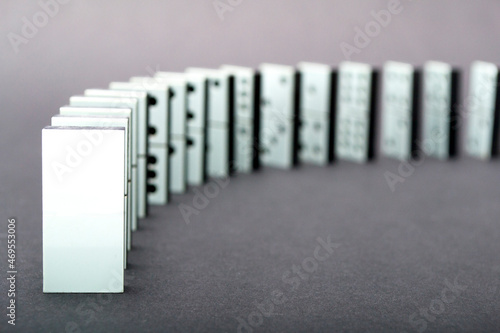 Dominoes falling in a row , gray background