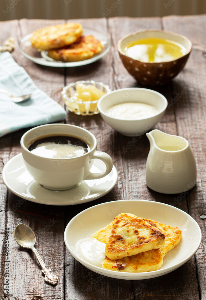 Breakfast of cheesecakes, coffee and tea. Cheesecakes of an unusual triangular shape. Breakfast of cheesecakes, coffee and tea. Cheesecakes of an unusual triangular shape.
