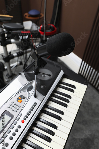 Modern synthesizer with microphone at recording studio. Music band practice