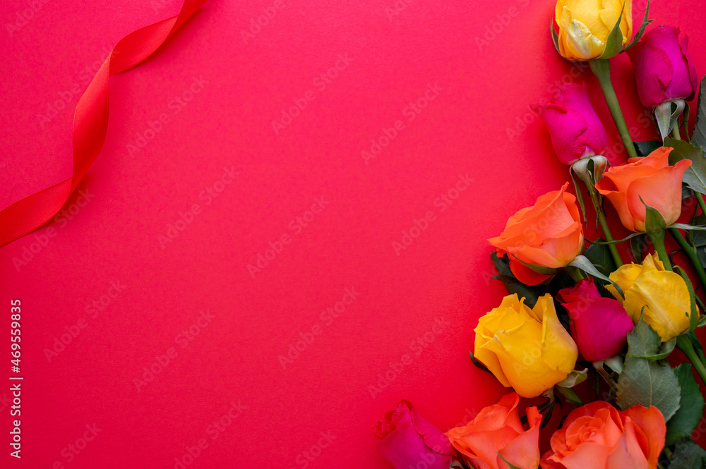Colorful roses flowers on red background, flat lay abstract Valentine's Day with copy space