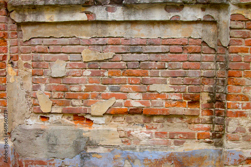 An old crumbling red brick wall. The red brick wall of the old building.