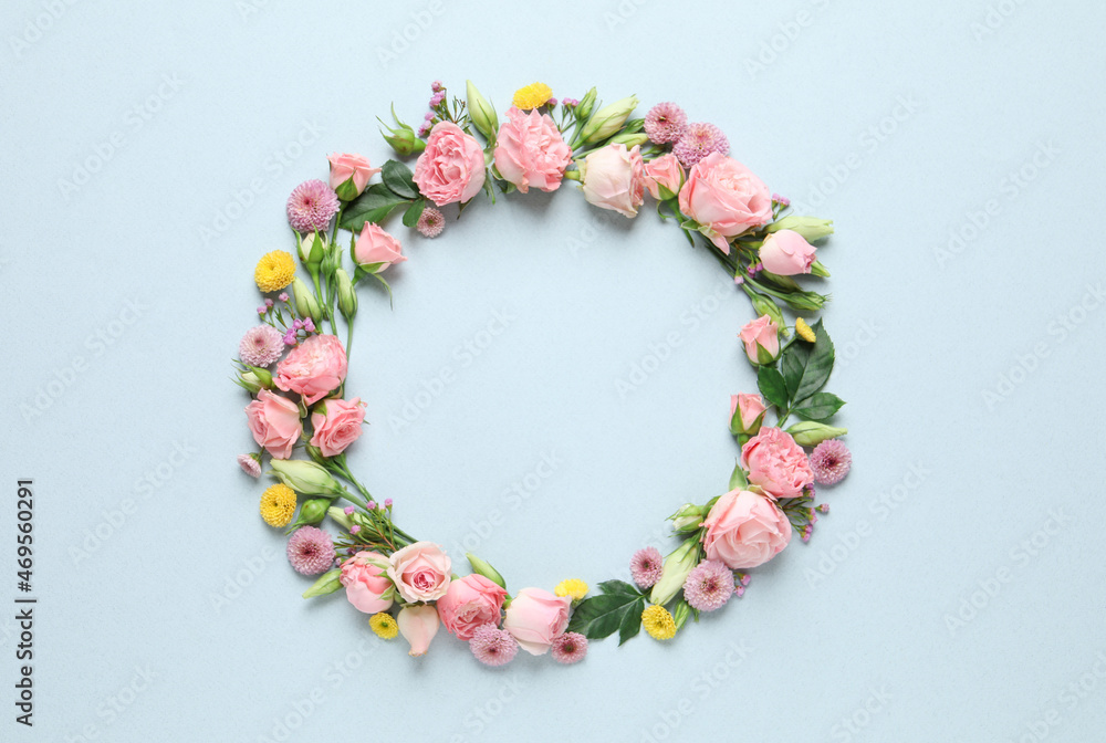 Wreath made of beautiful flowers and green leaves on light background, flat lay. Space for text