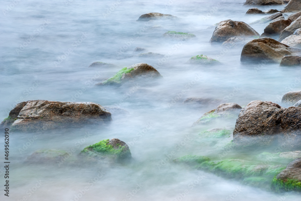 Sea stones in the water of the Mediterranean Sea. Water creates fog due to long exposure. Sea stones in the water of the Mediterranean Sea. Water creates fog due to long exposure.