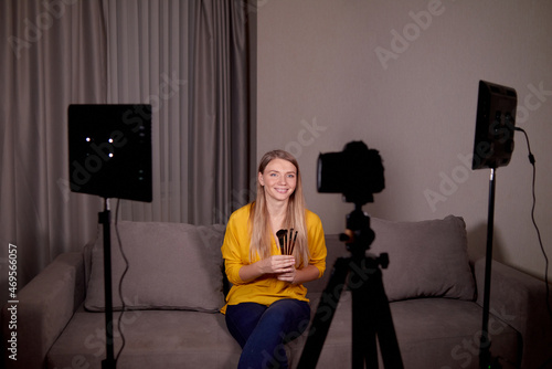 woman professional makeup artist records an online course or training for his students on camera at home using video light photo