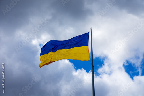 The national flag of Ukraine on a background of gray clouds. Concept. The wind is blowing.