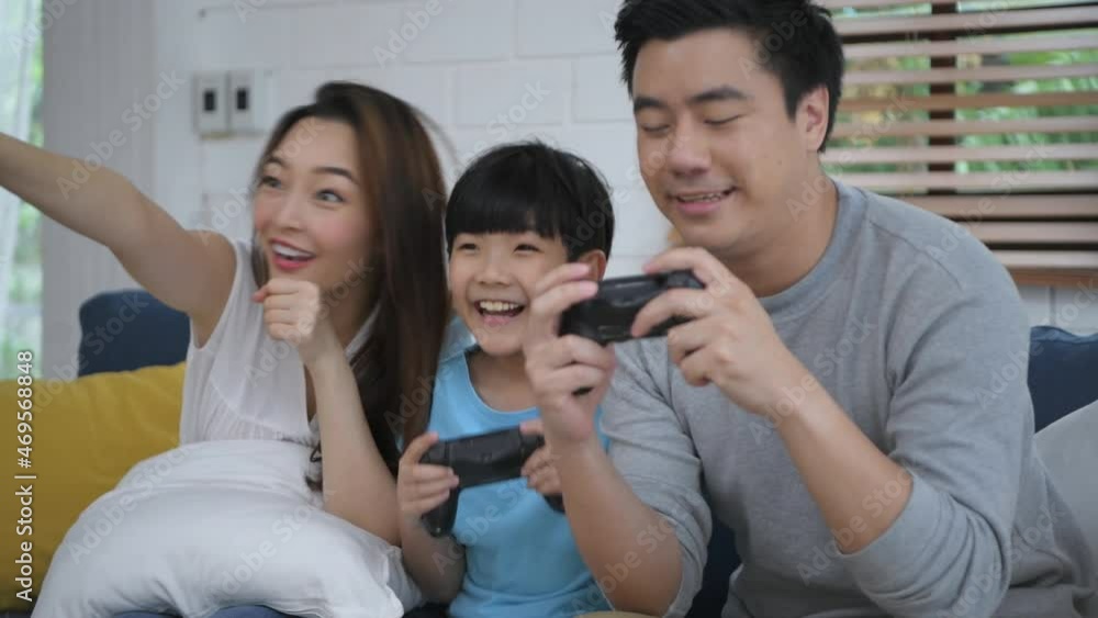 Family concept of 4k Resolution. Father and mother are playing games with their son in the living room. Activities to do together during the holidays. Family concept of 4k Resolution. Father and mother are playing games with their son in the living room. Activities to do together during the holidays.