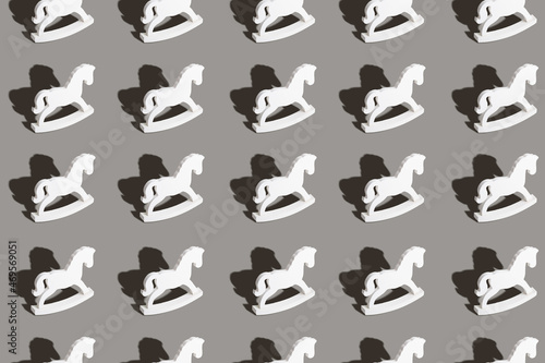 Christmas and New year concept. Seamless pattern made with wooden horse toys on light gray background. Flat lay.