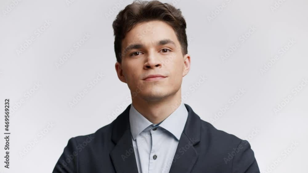 White collar worker. Young confident office manager fixing his jacket and looking at camera, white studio background White collar worker. Young confident office manager fixing his jacket and looking at camera, white studio background