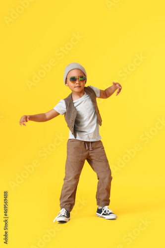 Fototapeta Naklejka Na Ścianę i Meble -  Cute dancing African-American boy on color background