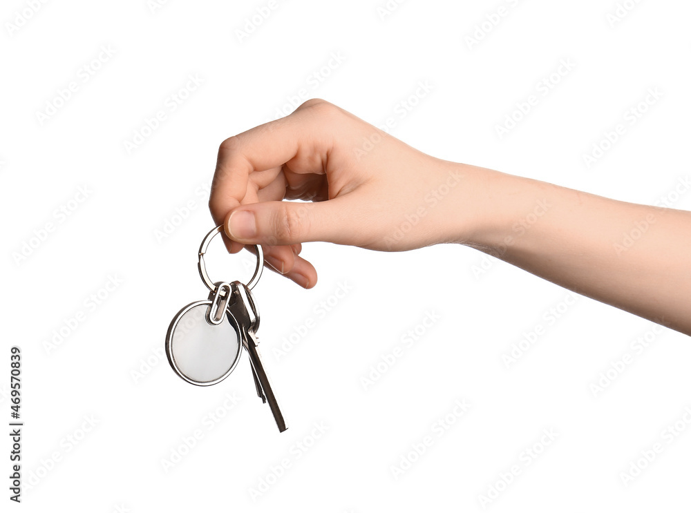 Female hand holding keys with round keychain on white background Female hand holding keys with round keychain on white background