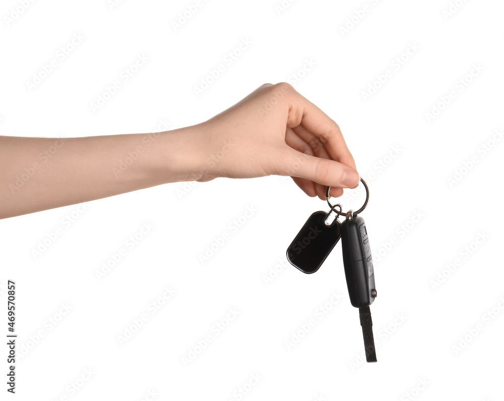 Female hand holding car key with keychain on white background Female hand holding car key with keychain on white background