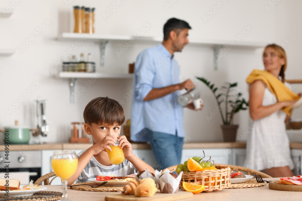 Little boy drinking juice at table in kitchen Little boy drinking juice at table in kitchen