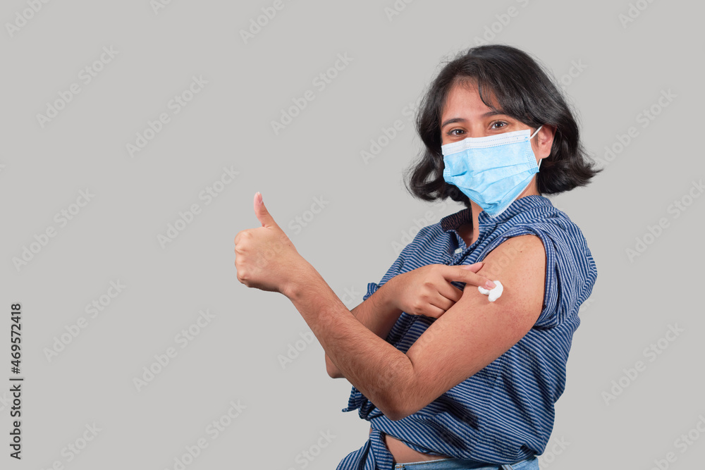 Young latin woman wearing freshly vaccinated face mask, isolated. Young latin woman wearing freshly vaccinated face mask, isolated.
