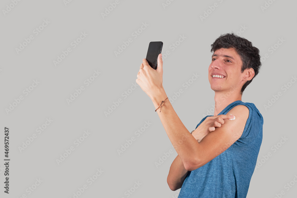 Young Latino man takes selfie after being vaccinated. Young Latino man takes selfie after being vaccinated.