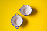 Empty plates for soup on yellow paper background.