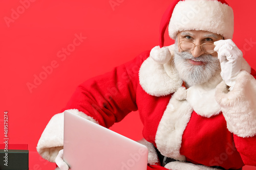 Santa Claus with modern lap...