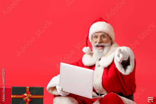 Santa Claus with laptop poi...