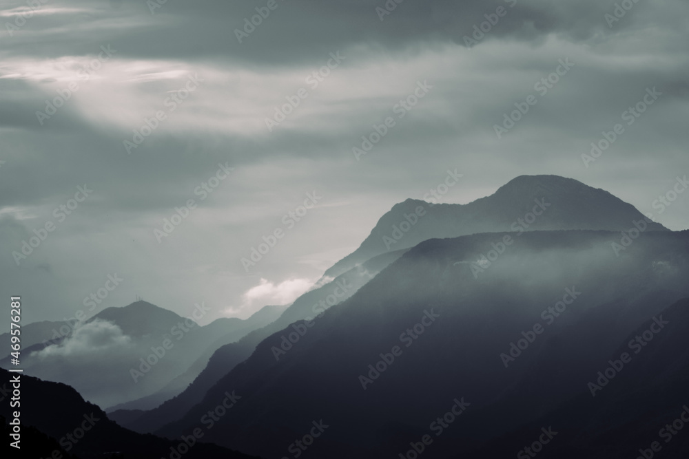 Mountain silhouettes. Foggy monochrome layered mountain silhouettes with clouds