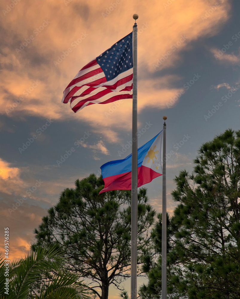 American and  Filipino flags against sky