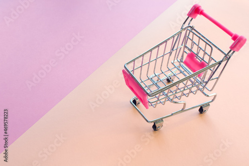 Shopping cart on pink and light yellow background
