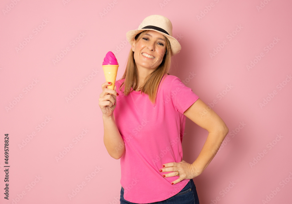Young happy woman wearing straw hat holding ice cream isolated over pink background. Young happy woman wearing straw hat holding ice cream isolated over pink background.