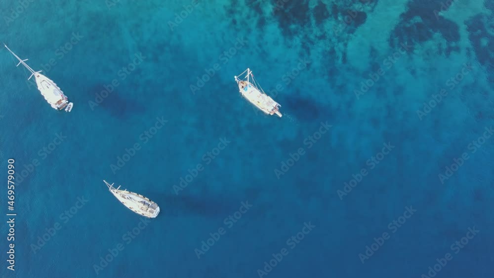 Sailing yachts anchored in the bay with clear and turquoise water. Aerial drone view Sailing yachts anchored in the bay with clear and turquoise water. Aerial drone view