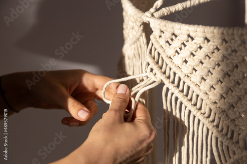 closeup weaving of macrame threads , women's hands photo