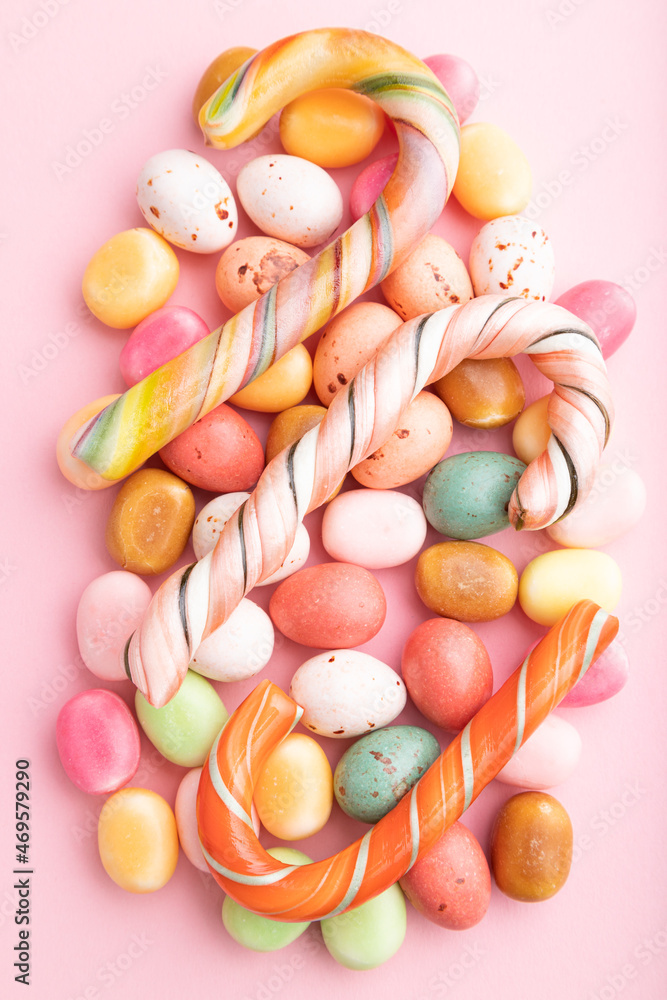Various caramel candies on pink background. close up, top view