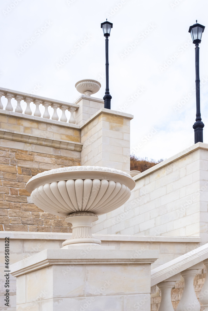 Stone staircase, decorated with columns and flowerpots, lampposts. Architecture and construction
