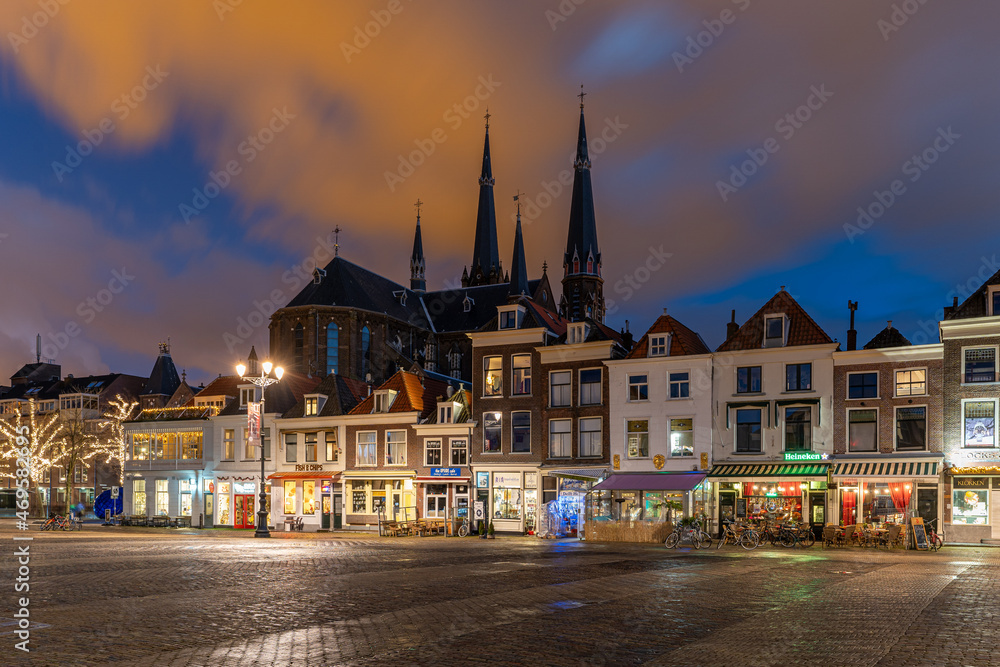 Obraz premium Delft Town Square at Sunset. A picturesque view of the historic town square of Delft bathed in the warm glow of sunset.