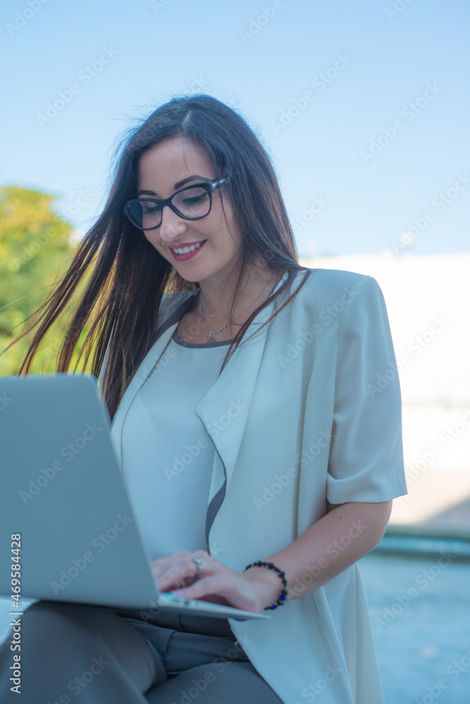 Smiling business girl behind a laptop. The concept of a business woman. Smiling business girl behind a laptop. The concept of a business woman.