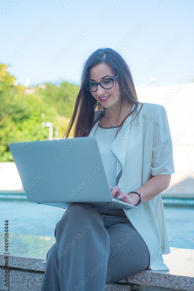 Smiling business girl behind a laptop. The concept of a business woman. 