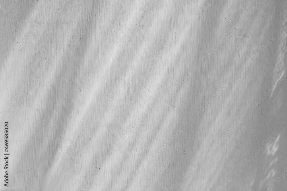 White wall shadow with line of sunlight rays. Sunny day inside the room background. White texture stucco paint coating. White wall shadow with line of sunlight rays. Sunny day inside the room background. White texture stucco paint coating.