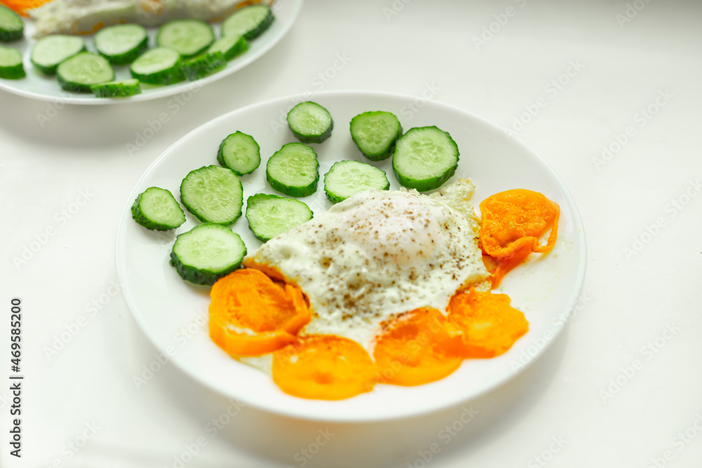 Soft focus, breakfast plate. Selective focus. Sliced cucumber, fried scrambled eggs close up. Soft focus, breakfast plate. Selective focus. Sliced cucumber, fried scrambled eggs close up.