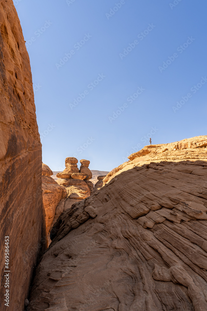 Person standing on sandstone columns in the desert region of Tabuk. AlUla, Saudi Arabia