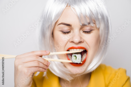 pretty woman in white wig and sushi with Japanese chopsticks