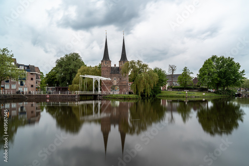 Delft Oostpoort, a historic gateway with a scenic reflection and cloudy sky
