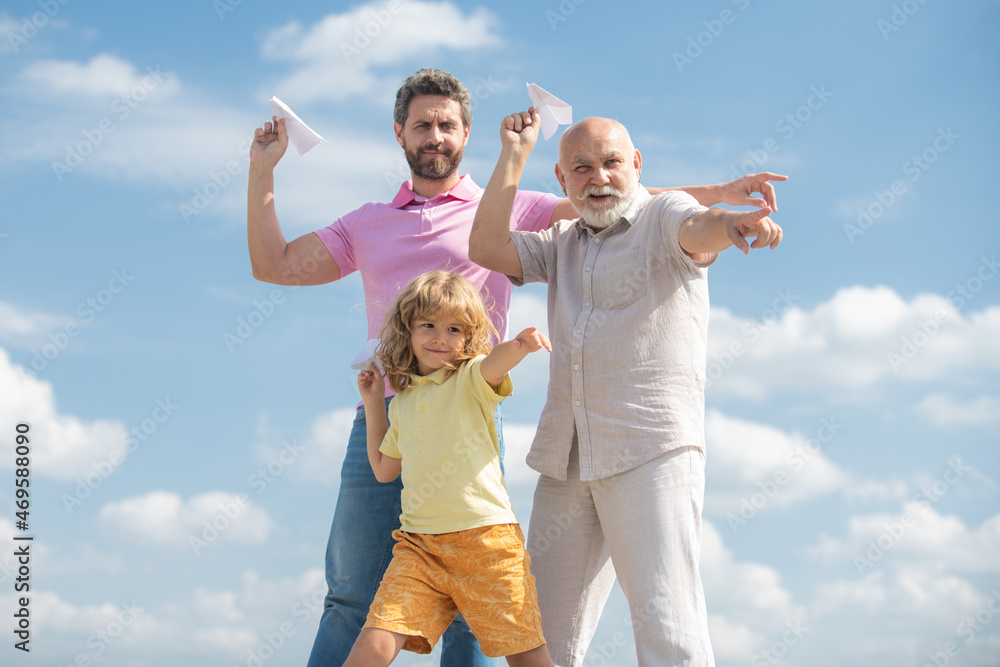 Active family leisure with kids. Boy son with father and grandfather with a toy airplane plays on summer sky background. Family adventure, imagination, innovation and inspiration. Active family leisure with kids. Boy son with father and grandfather with a toy airplane plays on summer sky background. Family adventure, imagination, innovation and inspiration.