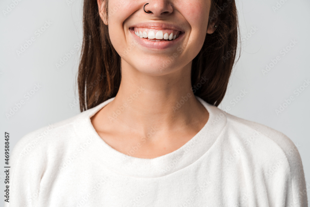 Close up view of the successful beautiful young stylish woman in casual closes standing with toothy smile. Studio shot isolated on white background Close up view of the successful beautiful young stylish woman in casual closes standing with toothy smile. Studio shot isolated on white background