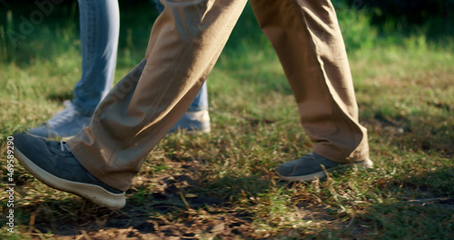 Two farmers legs walking garden together. Agronomists going in tree orchard.