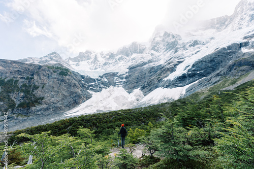 A female hiker stands in the French valley with mountains on the background, Torres del Paine National Park, Chile