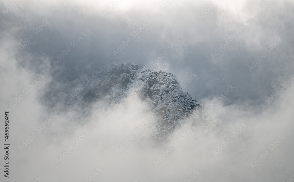 snow-capped mountain peak emerging from the mist