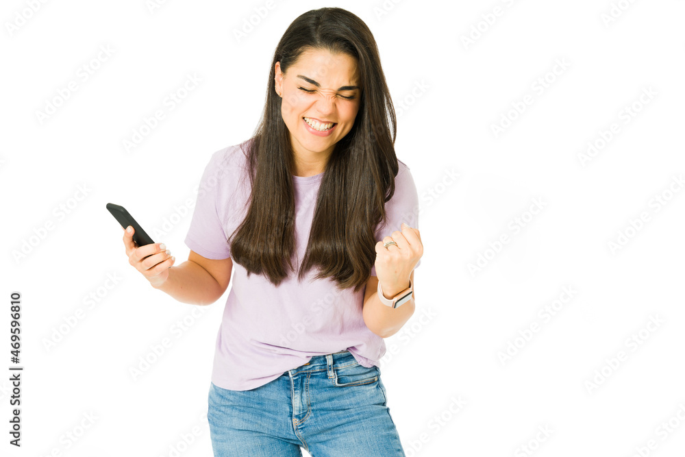 Happy woman celebrating with a smartphone Happy woman celebrating with a smartphone