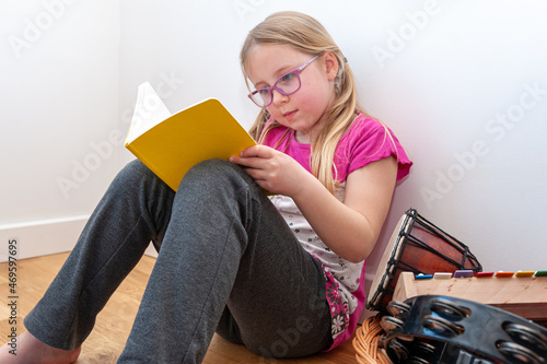 School age girl sitting in her bedroom and doing school homework. photo