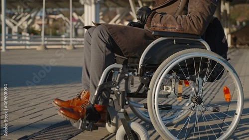 disability and immobility after injury or disease, man is sitting in wheelchair on street