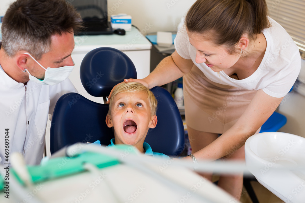 Fototapeta premium Boy with woman are visiting dentist in dental office.