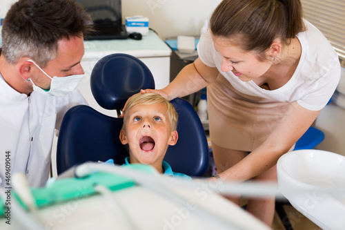 Boy with woman are visiting dentist in dental office.