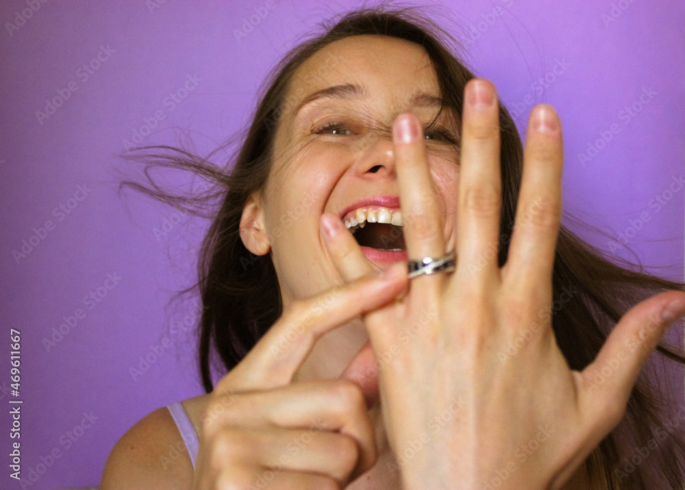 A beautiful excited brunette girl points at an engagement ring on finger, laugh. A beautiful excited brunette girl points at an engagement ring on finger, laugh.