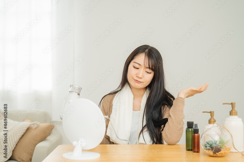 ドライヤーを使う女性(悩む)
ドライヤーを使う女性(悩む)
